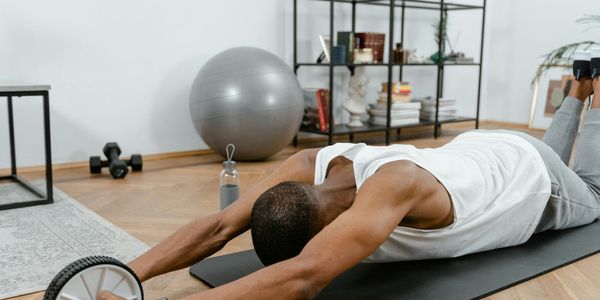 Man performing a slow, controlled core exercise on a mat.